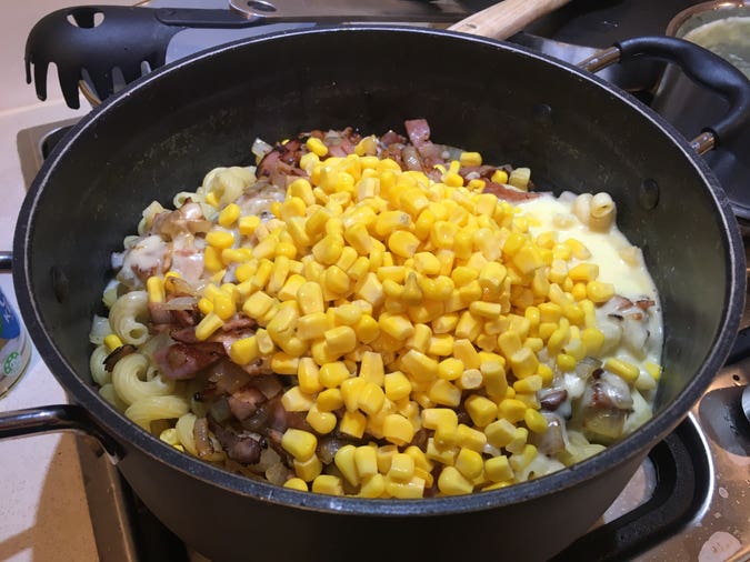 curls (pasta), onion, bacon, sauce, and corn kernels