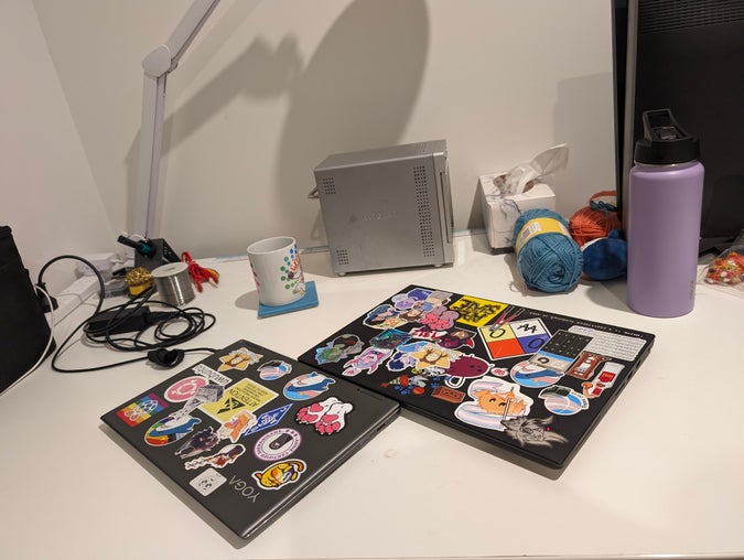 two very gay laptops spooning on a desk